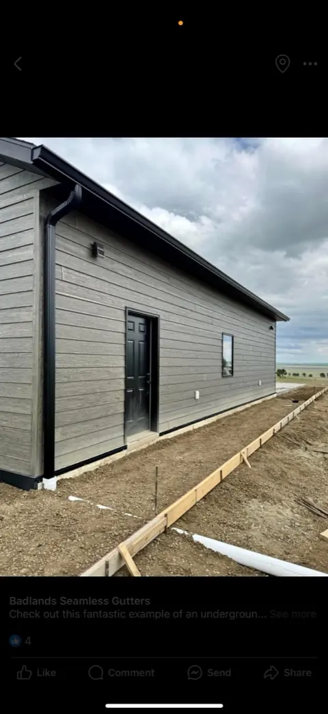 Black downspout against light siding