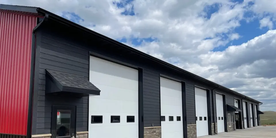 Gutters and downspouts on a commercial building with garage bays