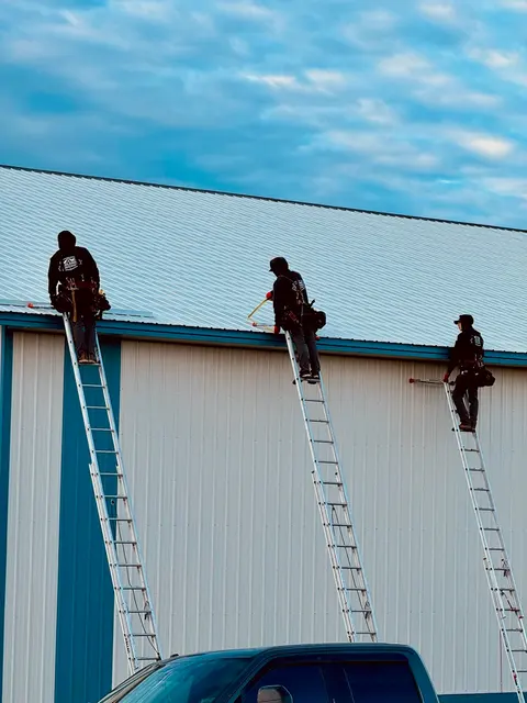 Crew working at the roof edge of a commercial building