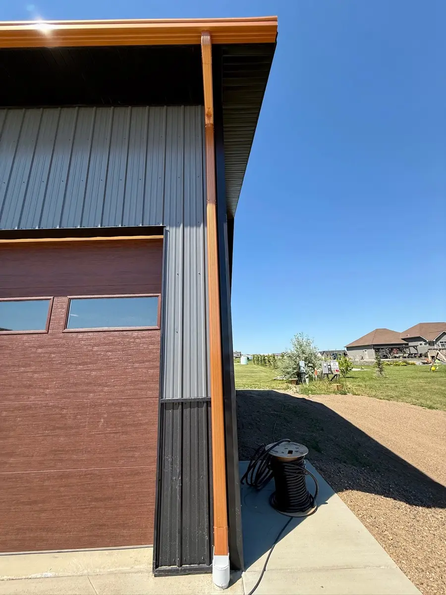 Downspout at the corner of a home directing water to an extension