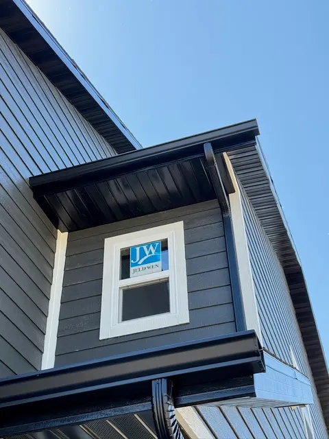 Black seamless gutter on a gray dormer