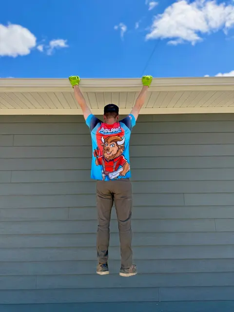 Installer hanging his full weight from an installed gutter guard
