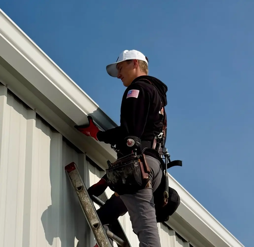 Installer fitting seamless aluminum gutter on a Coeur d'Alene home