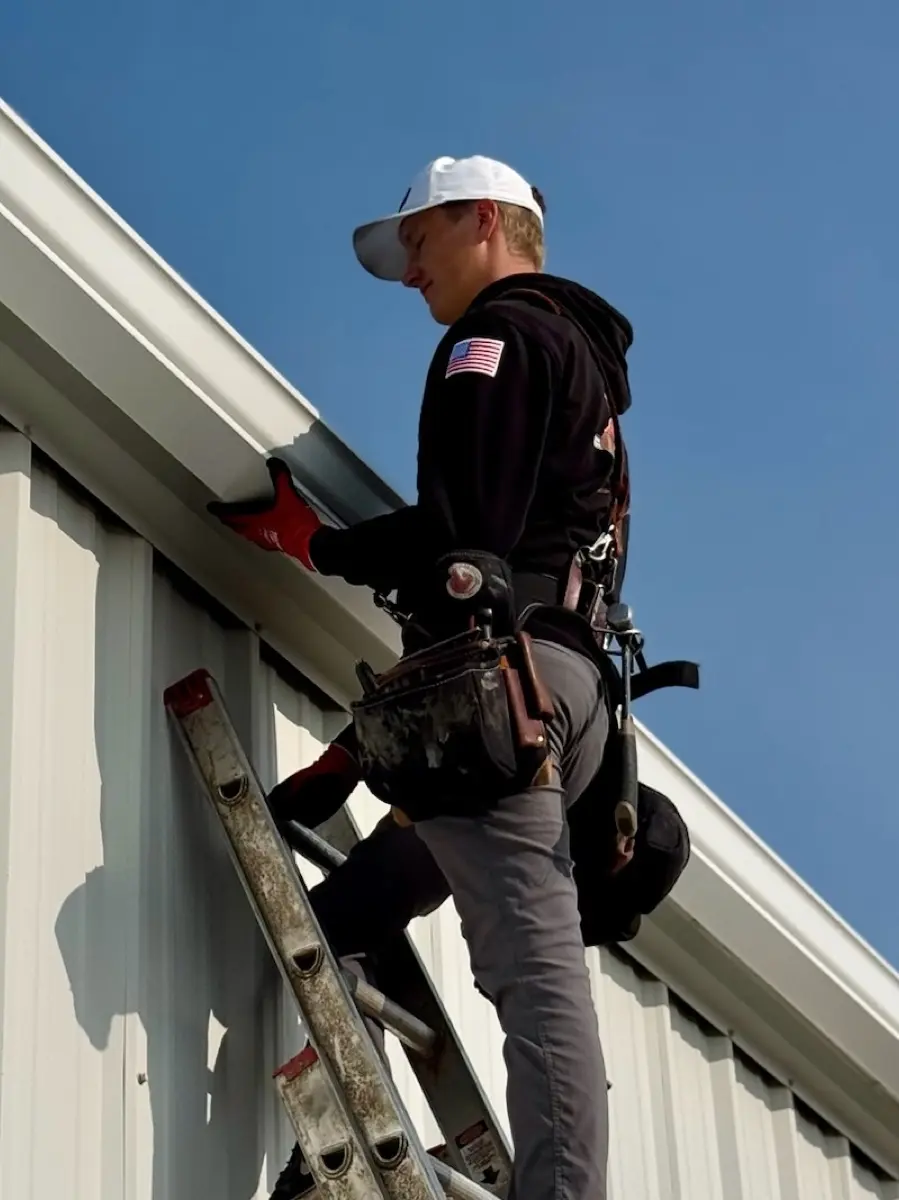 Technician repairing a storm-damaged gutter section