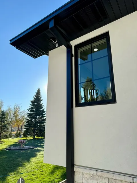 Black seamless gutter on a stucco home